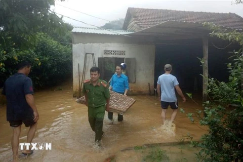 Lực lượng chức năng hỗ trợ người dân thôn Xuân Thượng, xã Đạ Pal, huyện Đạ Tẻh, Lâm Đồng, di dời đồ đạc, tài sản đến nơi an toàn. (Ảnh: Nguyễn Dũng/TTXVN)