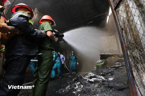 Cảnh sát căng mình dập lửa tại Khu công nghiệp Sài Đồng. (Ảnh: Lê Minh Sơn/Vietnam+)