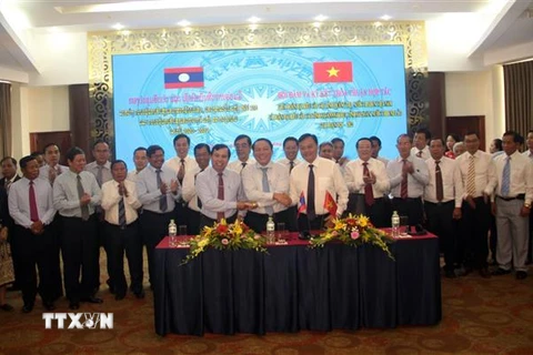 Trưởng đoàn đại biểu ba tỉnh Quảng Trị, Savannakhet, Salavan bắt tay đoàn kết, hữu nghị sau khi ký kết văn bản thỏa thuận hợp tác. (Ảnh: Trịnh Bang Nhiệm/TTXVN)