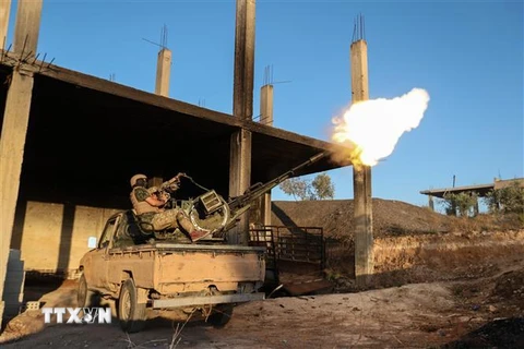 Tay súng thuộc nhóm cực đoan có liên hệ với tổ chức al-Qaeda đụng độ với lực lượng ủng hộ chính quyền ở tỉnh Idlib, Syria. (Ảnh: AFP/TTXVN)