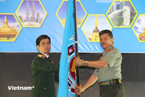 Thiếu tướng Hoàng Kim Phụng nhận cờ đăng cai tổ chức Hội nghị APCN năm 2020 tại Việt Nam. (Ảnh: Hà Ngọc-Hoàng Nhương/Vietnam+)