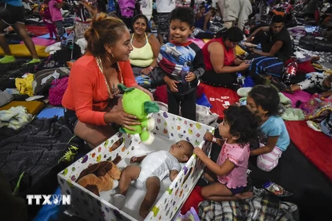 Trẻ em di cư trong hành trình theo cha mẹ tới Mỹ tại lều tạm ở Mexico City, Mexico. (Ảnh: AFP/TTXVN)