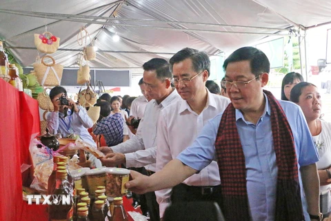 Phó Thủ tướng Vương Đình Huệ và đại biểu tham quan gian trưng bày nông sản của các tỉnh tại hội nghị. (Ảnh: Nhật Bình/TTXVN)