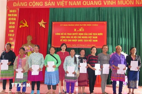 Lãnh đạo Bộ Tư pháp trao quyết định nhập quốc tịch Việt Nam cho các công dân Lào. (Ảnh: Hữu Quyết/TTXVN)