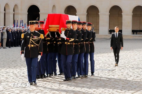 Tổng thống Pháp Emmanuel Macron (phải) bên linh cữu cố Tổng thống Jacques Chirac trong lễ tang ở thủ đô Paris ngày 30/9. (Ảnh: AFP/TTXVN)