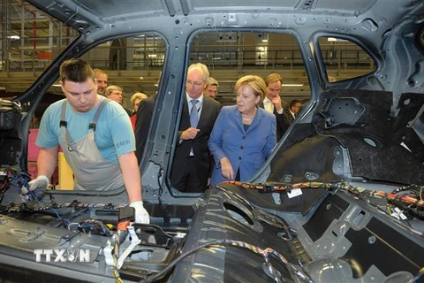 Thủ tướng Đức Angela Merkel (phải) thăm một nhà máy sản xuất xe BMW ở Leipzig, miền Đông Đức. (Ảnh: AFP/TTXVN)