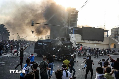 Người biểu tình bạo động xung đột với cảnh sát tại khu vực giữa quảng trường Tahrir và vùng Xanh ở thủ đô Baghdad, Iraq. (Ảnh: AFP/TTXVN)