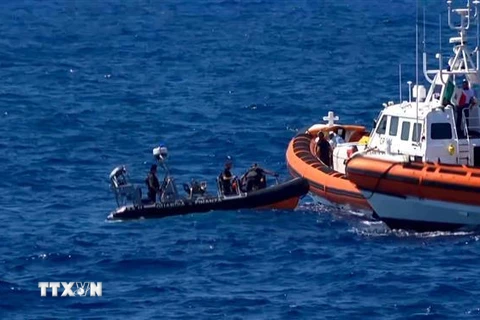 Người di cư trên tàu cứu hộ Open Arms được tàu tuần tra Tây Ban Nha giải cứu sau khi nhảy xuống biển ở khu vực ngoài khơi đảo Lampedusa, Italy. (Ảnh: AFP/TTXVN)