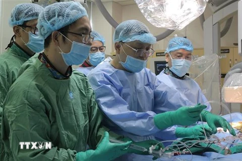 Các bác sỹ Bệnh viện Đại học Y dược Thành phố Hồ Chí Minh thực hiện thay van động mạch chủ qua da cho bệnh nhân. (Ảnh: TTXVN phát)