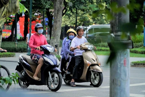 Nhiều phụ huynh đưa con đi học cũng đã trang bị cho con em mình những chiếc áo khoác giữ ấm vào buổi sáng sớm. (Ảnh: Minh Hiếu/Vietnam+)