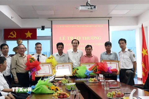 Ông Lê Thanh Liêm, Phó Chủ tịch Thường trực UBND Thành phố Hồ Chí Minh trao Bằng khen cho các cá nhân có thành tích xuất sắc trong công tác cứu hộ, cứu nạn. (Ảnh: Xuân Khu/TTXVN)