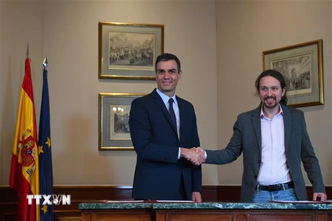 Thủ tướng tạm quyền Tây Ban Nha Pedro Sanchez (trái) và lãnh đạo đảng Unidas Podemos, ông Pablo Iglesias sau lễ ký thỏa thuận sơ bộ về thành lập Chính phủ liên minh tại thủ đô Madrid. (Ảnh: AFP/TTXVN)
