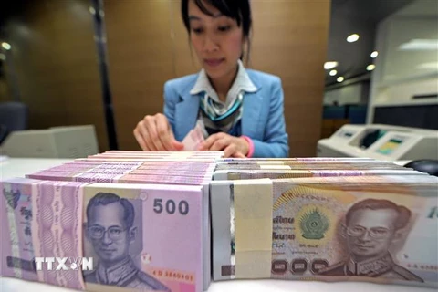 Kiểm tiền baht của Thái Lan tại ngân hàng ở Bangkok. (Ảnh: AFP/TTXVN)