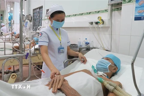 Điều dưỡng viên Bệnh viện Phạm Ngọc Thạch chăm sóc bệnh nhân lao phổi. (Ảnh: Đinh Hằng/TTXVN)
