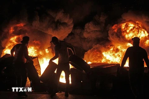 Người biểu tình đốt phá phong tỏa một tuyến đường ở thành phố Sidon, miền nam Liban. (Ảnh: AFP/TTXVN)