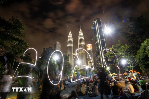 Người dân đón thời khắc giao thừa trong lễ hội năm mới ở tòa tháp đôi Petronas, Kuala Lumpur, Malaysia. (Ảnh: THX/TTXVN)