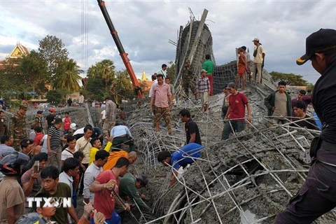 Lực lượng cứu hộ tìm kiếm nạn nhân dưới đống đổ nát sau vụ sập công trình xây dựng ở chùa Prasat Korkchak thuộc tỉnh Siem Reap, Campuchia. (Ảnh: THX/TTXVN)