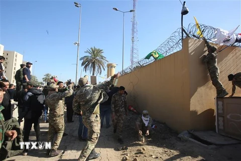 Các tay súng thuộc nhóm phiến quân Hashd al-Shaabi biểu tình bên ngoài sứ quán Mỹ ở Baghdad, Iraq. (Ảnh: AFP/TTXVN)