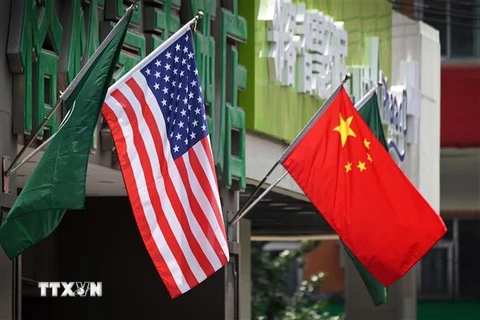 Quốc kỳ Trung Quốc (phải) và quốc kỳ Mỹ bên ngoài một khách sạn ở Bắc Kinh (Trung Quốc). (Ảnh: AFP/TTXVN)