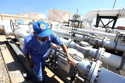 Công nhân kiểm tra đường ống dẫn dầu tại cảng dầu Zawiya, Libya. (Ảnh: AFP/TTXVN)