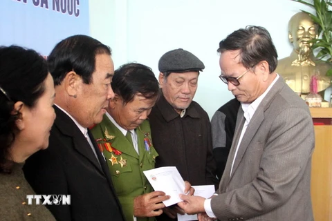 Ông Lê Xuân Tánh (phải) - Chủ tịch hội Chiến sỹ Thành cổ Quảng Trị - trao quà cho các hội viên. (Ảnh: Trịnh Bang Nhiệm/TTXVN)