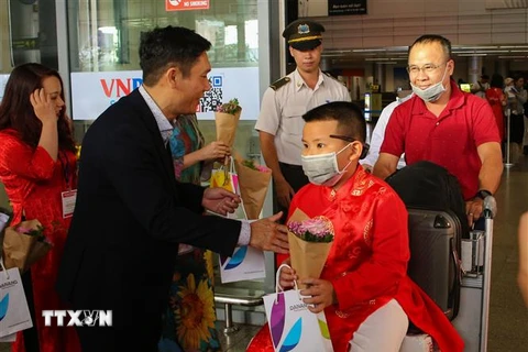 Tặng hoa, quà chúc mừng các vị khách đầu tiên đến xông đất Đà Nẵng bằng đường hàng không. (Ảnh: Trần Lê Lâm/TTXVN)