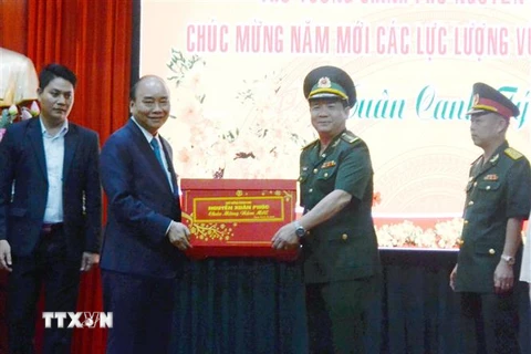Thủ tướng Nguyễn Xuân Phúc tặng quà Tết cho cán bộ, chiến sỹ Công an thành phố Đà Nẵng. (Ảnh: Quốc Dũng/TTXVN)
