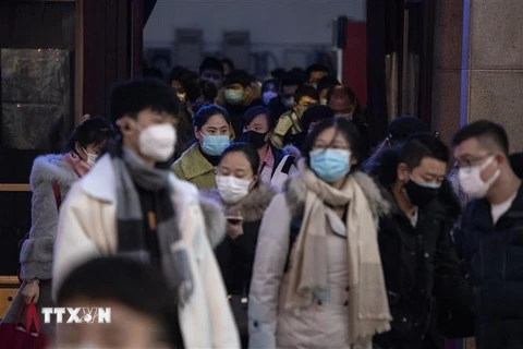 Người dân đeo khẩu trang để phòng tránh lây nhiễm virus corona tại nhà ga tàu hỏa ở Bắc Kinh, Trung Quốc. (Ảnh: AFP/TTXVN)