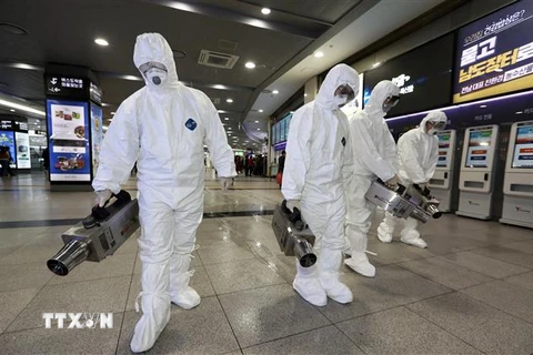 Nhân viên y tế khử trùng tại bến xe buýt ở Gwangju, Hàn Quốc nhằm ngăn chặn sự lây lan của virus n-CoV. (Ảnh: AFP/TTXVN)