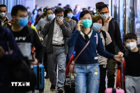 Hành khách đeo khẩu trang đề phòng lây nhiễm virus 2019-nCoV tại một nhà ga ở Hong Kong, Trung Quốc. (Ảnh: AFP/TTXVN)