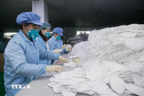 Công nhân sản xuất khẩu trang y tế tại Công ty công nghệ thanh lọc Yuanqin Thượng Hải, Trung Quốc. (Ảnh:THX/TTXVN)