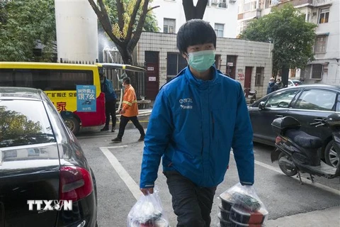 Một tài xế giao đồ ăn tới bệnh viện ở Vũ Hán, tỉnh Hồ Bắc, Trung Quốc. (Ảnh: THX/TTXVN)