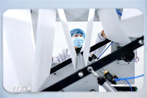 Công nhân làm việc tăng ca để sản xuất trang phục bảo hộ y tế tại Công ty công nghệ y tế ở Hồ Châu, tỉnh Chiết Giang, Trung Quốc. (Ảnh: THX/TTXVN)