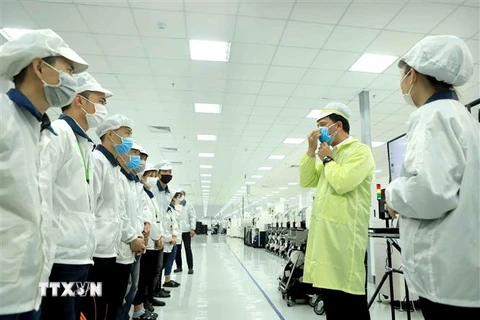 Công ty TNHH Compal Việt Nam trong khu công nghiệp Bá Thiện 1 (huyện Bình Xuyên) hướng dẫn cho công nhân đeo khẩu trang đúng cách để phòng dịch COVID-19. (Ảnh: Hoàng Hùng/TTXVN)
