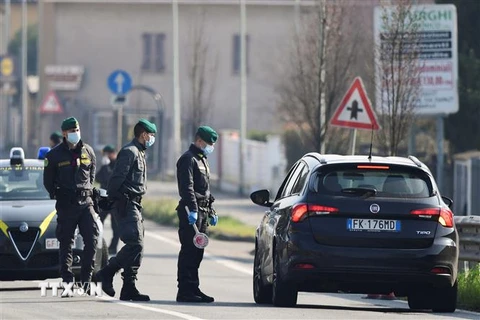 Lực lượng chức năng Italy hướng dẫn lưu thông tại thị trấn nhỏ Zorlesco, phía Đông Nam Milan. (Ảnh: AFP/TTXVN)