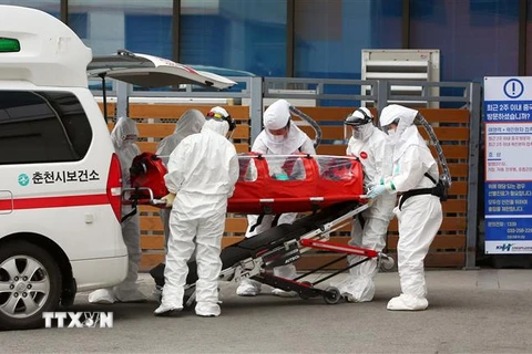 Nhân viên y tế chuyển bệnh nhân nhiễm dịch viêm đường hô hấp cấp COVID-19 tới bệnh viện ở thành phố Chuncheon. (Ảnh: AFP/TTXVN)