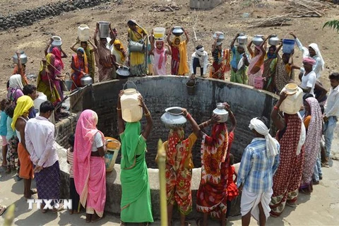 Người dân lấy nước uống tại một giếng nước ở bang Madhya Pradesh, Ấn Độ. (Ảnh: AFP/TTXVN)