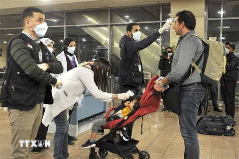 Kiểm tra thân nhiệt nhằm ngăn chặn sự lây lan của virus COVID-19 tại sân bay quốc tế Cairo, Ai Cập. (Ảnh: AFP/TTXVN)