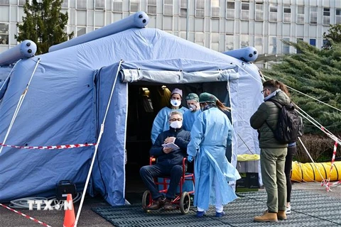 Nhân viên y tế hỗ trợ bệnh nhân nghi nhiễm COVID-19 tại khu cách ly của một bệnh viện ở Cremona, miền Bắc Italy. (Ảnh: AFP/TTXVN)