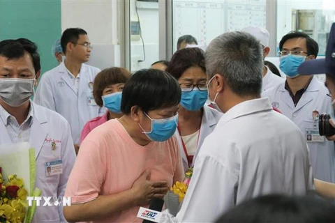 Bệnh nhân Li Ding (áo hồng), một trong hai bện nhân nhiễm SARS-CoV-2, cúi đầu cảm ơn các bác sỹ Việt Nam. (Ảnh: Đinh Hằng/TTXVN)