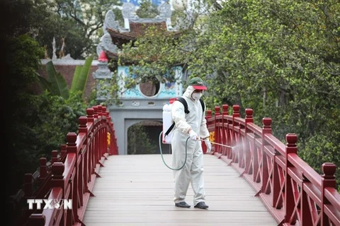 Phun thuốc tiêu độc khử trùng tại cầu Thê Húc. (Ảnh: Thành Đạt/TTXVN)