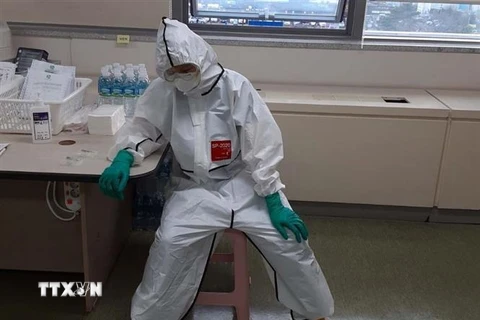 Một nhân viên y tế nghỉ ngơi sau khi kiệt sức vì chăm sóc bệnh nhân nhiễm COVID-19 tại một bệnh viện ở Changwon, Hàn Quốc. (Ảnh: YONHAP/TTXVN)