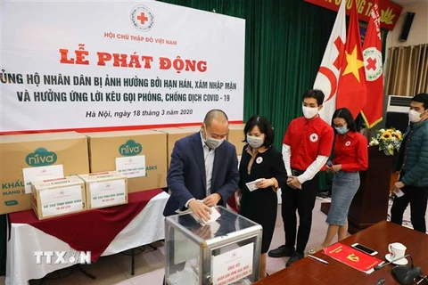 Cán bộ, hội viên Trung ương Hội Chữ thập Đỏ Việt Nam quyên góp, ủng hộ tại lễ phát động. (Ảnh: Thanh Tùng/TTXVN)