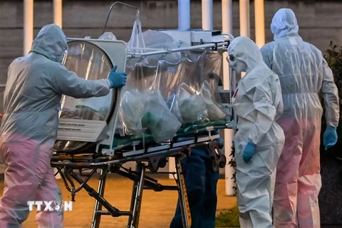 Nhân viên y tế chuyển bệnh nhân nhiễm COVID-19 tới bệnh viện ở Rome, Italy. (Ảnh: AFP/TTXVN)