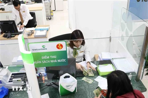 Người dân nộp thuế tại điểm thu Ngân hàng Vietcombank chi nhánh thành phố Cần Thơ. (Ảnh: Vũ Sinh/TTXVN)