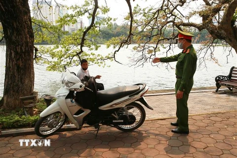 Công an quận Hoàn Kiếm đi kiểm tra, nhắc nhở nơi tập trung đông người tại Hồ Hoàn Kiếm. (Ảnh: Doãn Tấn/TTXVN)