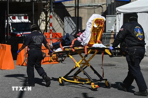 Nhân viên y tế chuyển bệnh nhân nhiễm COVID-19 tới trung tâm y tế Brooklyn, New York, Mỹ. (Ảnh: AFP/TTXVN)