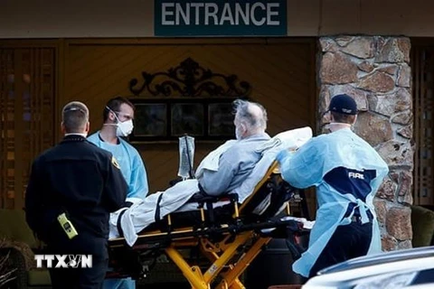 Nhân viên y tế chuyển bệnh nhân nhiễm COVD-19 lên xe cứu thương tại viện dưỡng lão Life Care Center ở Kirkland, bang Washington, Mỹ. (Ảnh: Reuters/TTXVN)