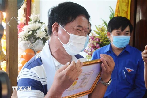 Bố của Thượng sỹ Võ Văn Toàn không cầm nổi nước mắt khi đón nhận Huy hiệu Tuổi trẻ dũng cảm của Trung ương Đoàn truy tặng cho con trai. (Ảnh: Văn Dũng/TTXVN)