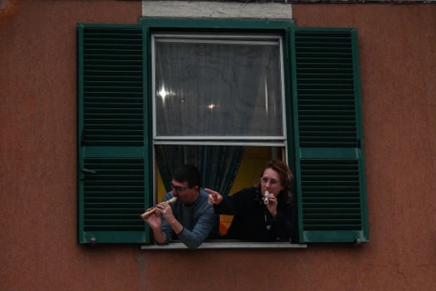Người dân Italy tham gia sự kiện Flashmod âm nhạc trên ban công nhằm thể hiện tinh thần đoàn kết quyết tâm đẩy lui dịch bệnh COVID-19 tại Rome. (Ảnh: AFP/TTXVN) 